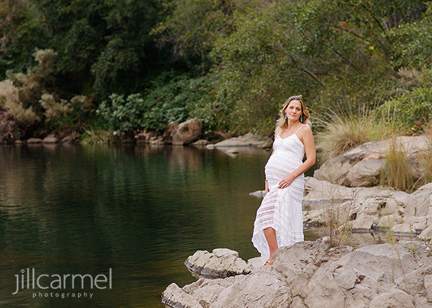 maternity portraits by the river in Old Sacramento wearing a white dress
