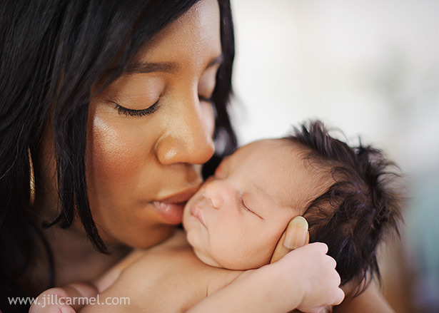 mommy kissing her brand new baby next to a soft light window in sacramento