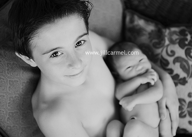 big brother holding his newborn sister for her pictures in Sacramento