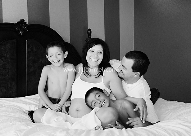 all the family on the bed laughing for mom pregnancy photo shoot