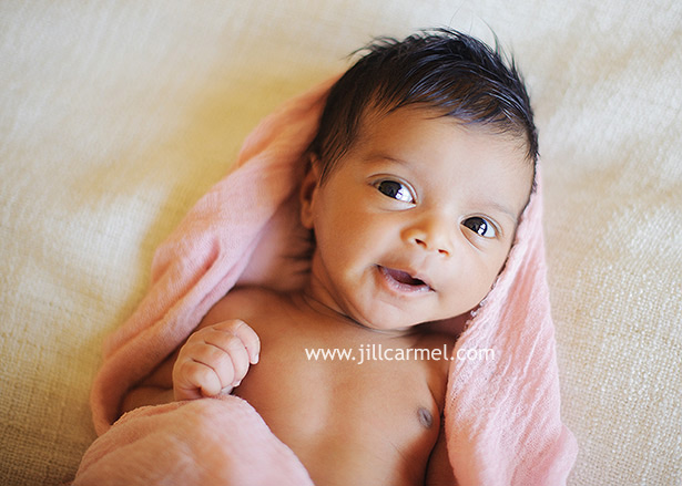 big brown eyes and smiles from this sacramento baby swaddled in a pink wrap