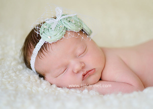 outfitted with a green headband for her newborn pictures