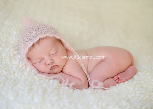 wearing a little pink knit cap for her rancho cordova newborn portraits