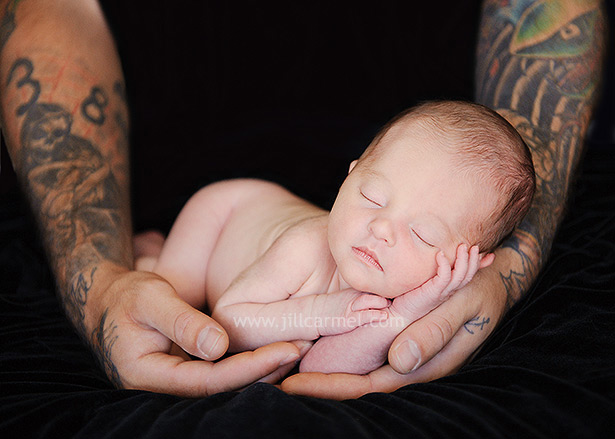 newborn baby in daddy's arms with tattoos