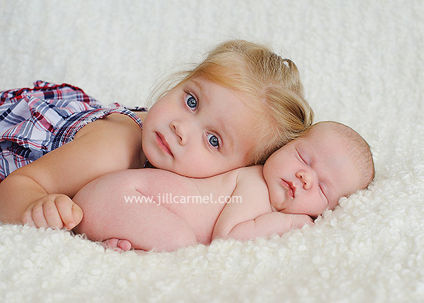 big sister taking her first picture with her baby newborn sister