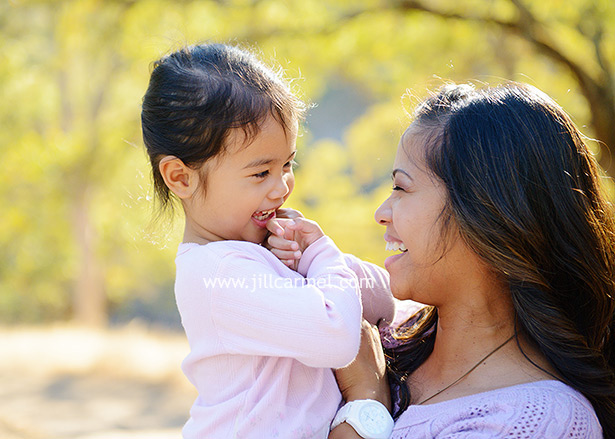 mommy makes her daughter giggle for their family portraits in fairfield