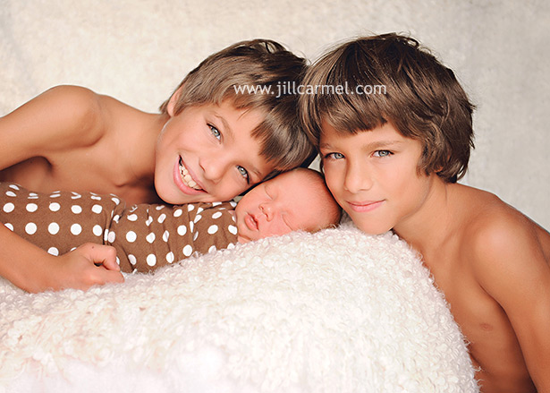 two gorgeous twin brothers pose with Sacramento newborn