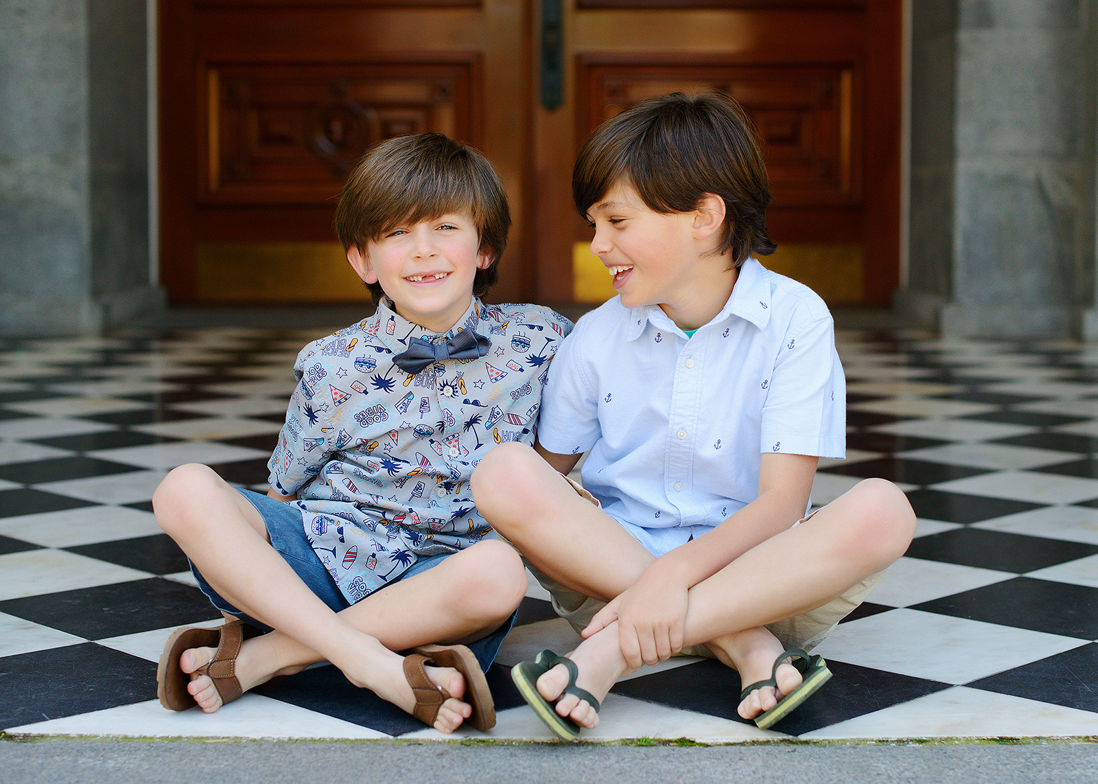 Brothers with bow tie smiling on patterned tile at the sacramento capitol