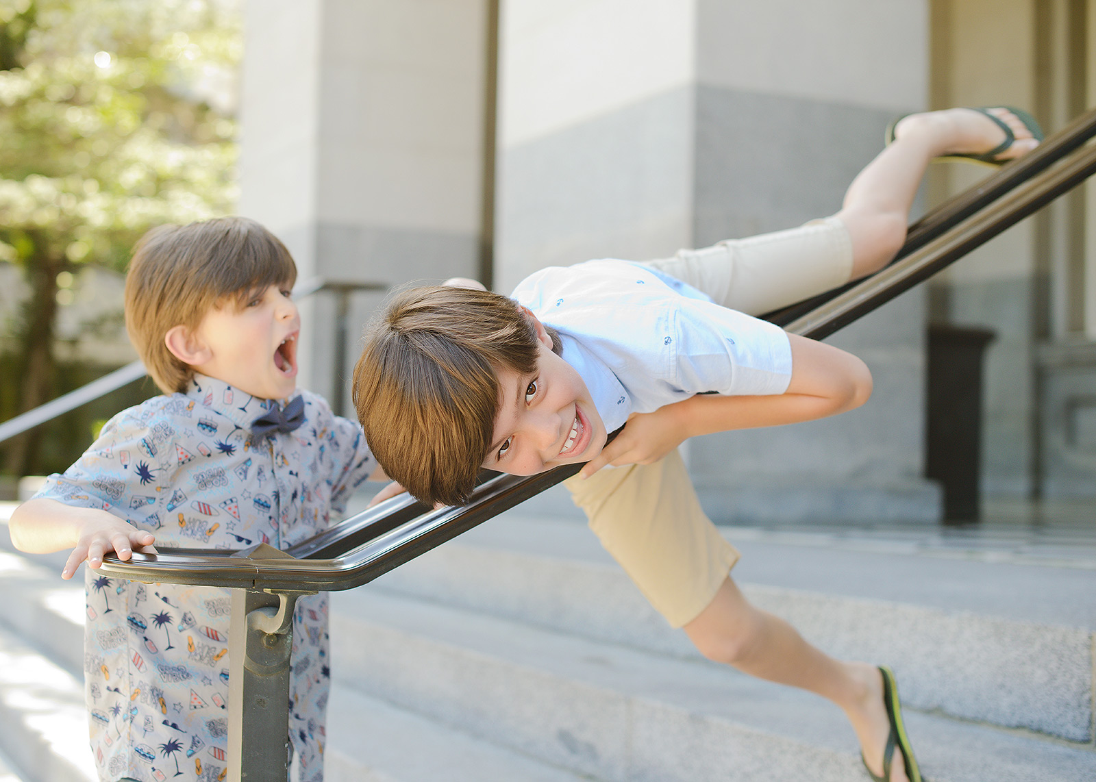 Brothers having fun on stair railing at the sacramento capitol