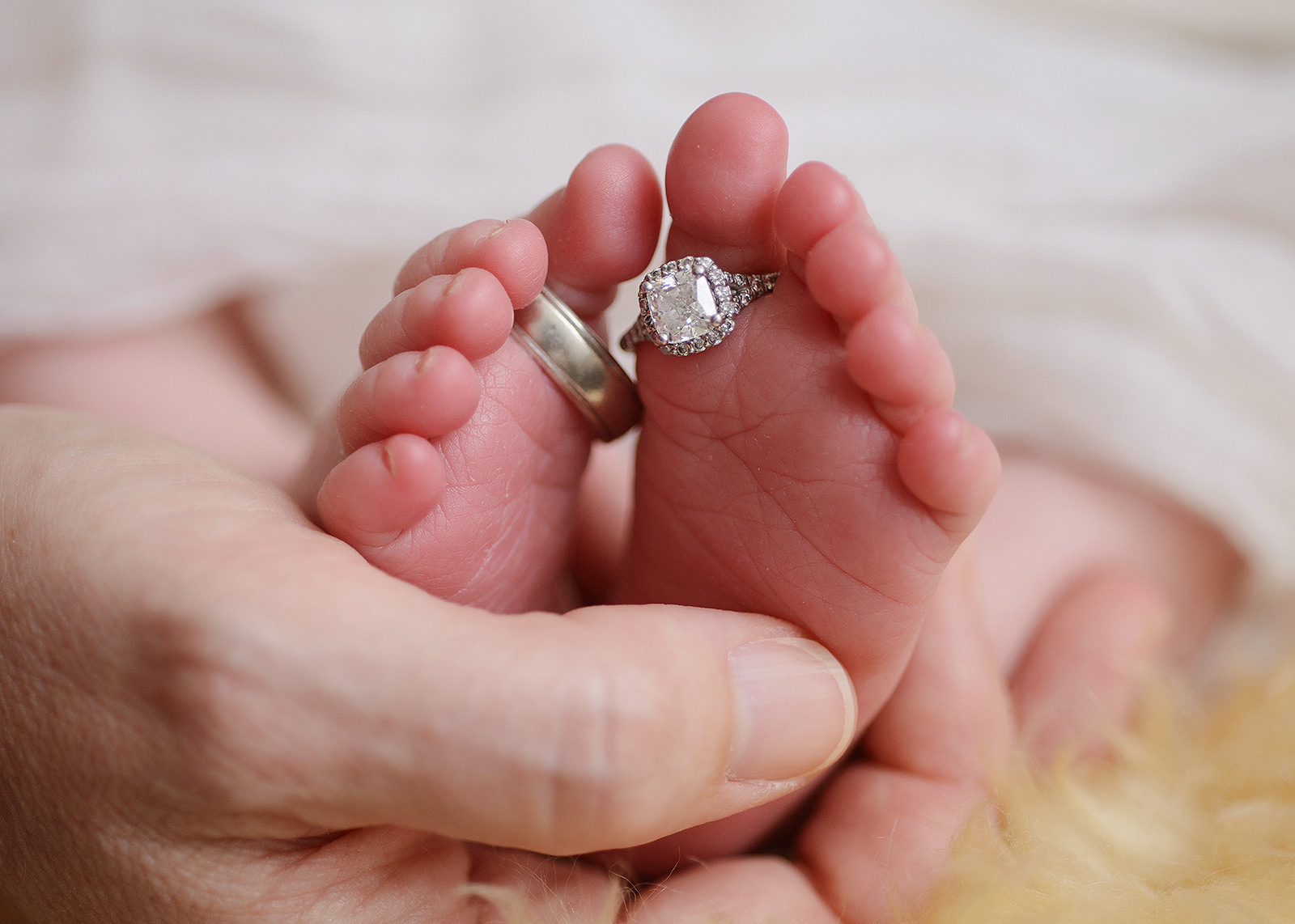 Newborn baby toes with wedding rings
