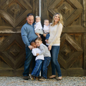 Family of six standing in front of detailed door