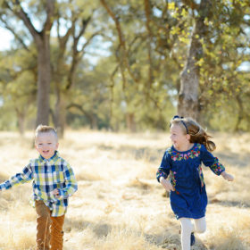 Brother and Sister Running Through Yellow Grass Field