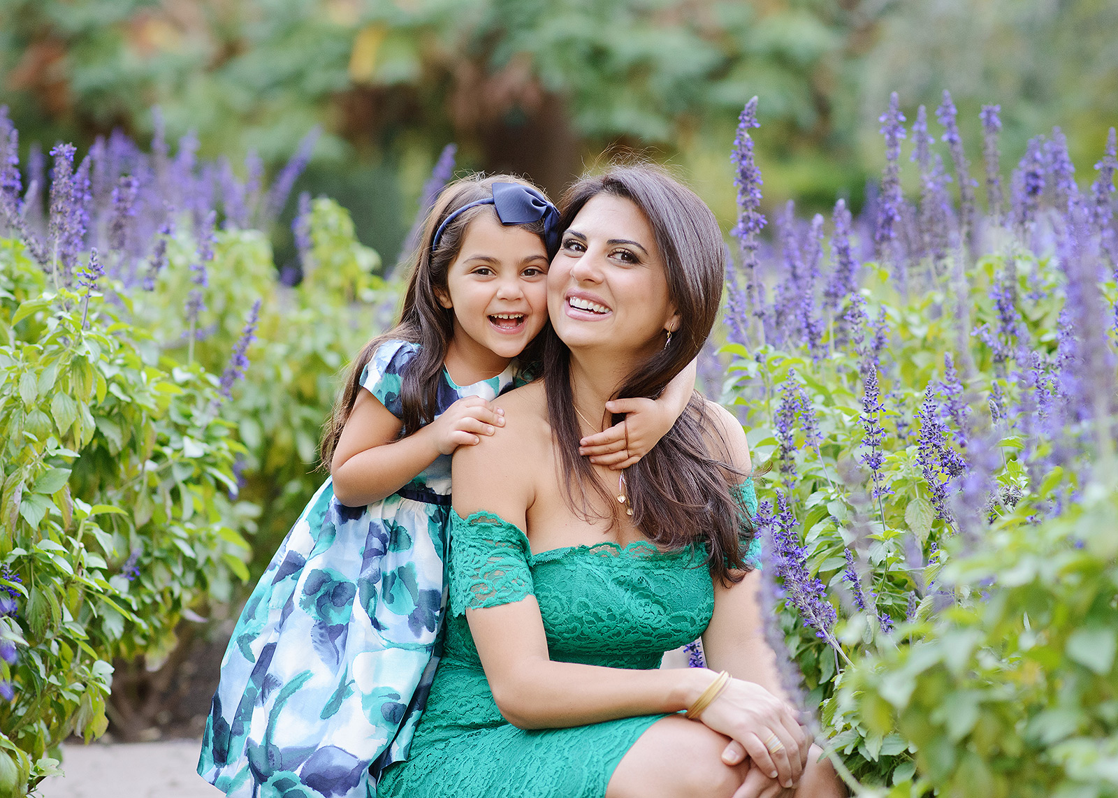 Mother and daughter hugging and smiling in front of lavender flowers