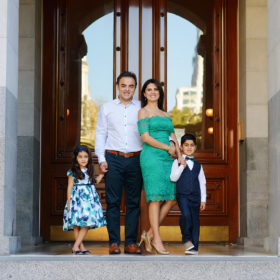 Family posing in front of the doors to the State Capitol