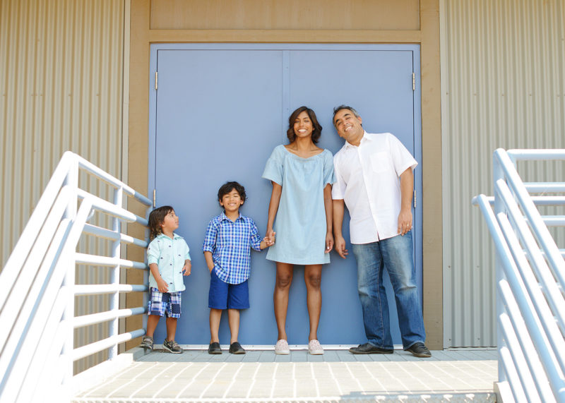 Family portrait in front of baby blue door stairway at Folsom Powerhouse