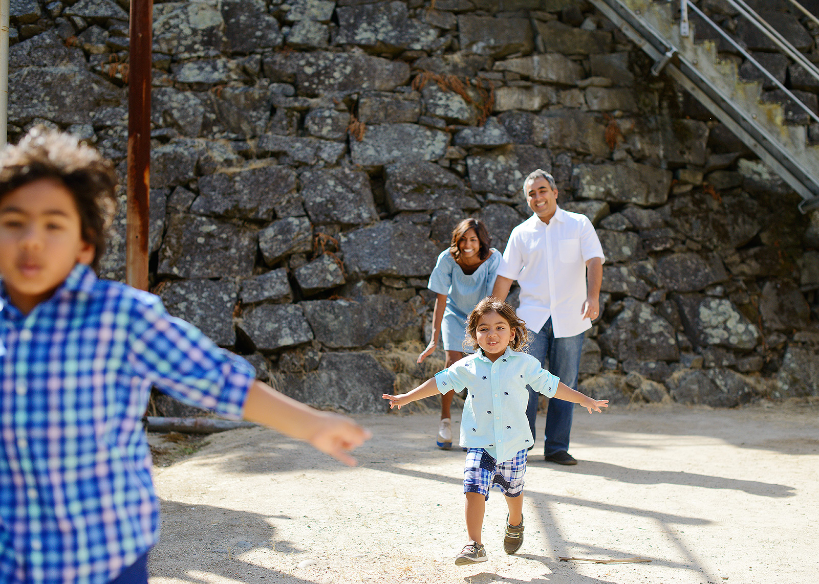 Boys running from mom and dad with stone background at Folsom Powerhouse