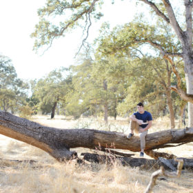 Male teenager sitting on fallen log in Folsom