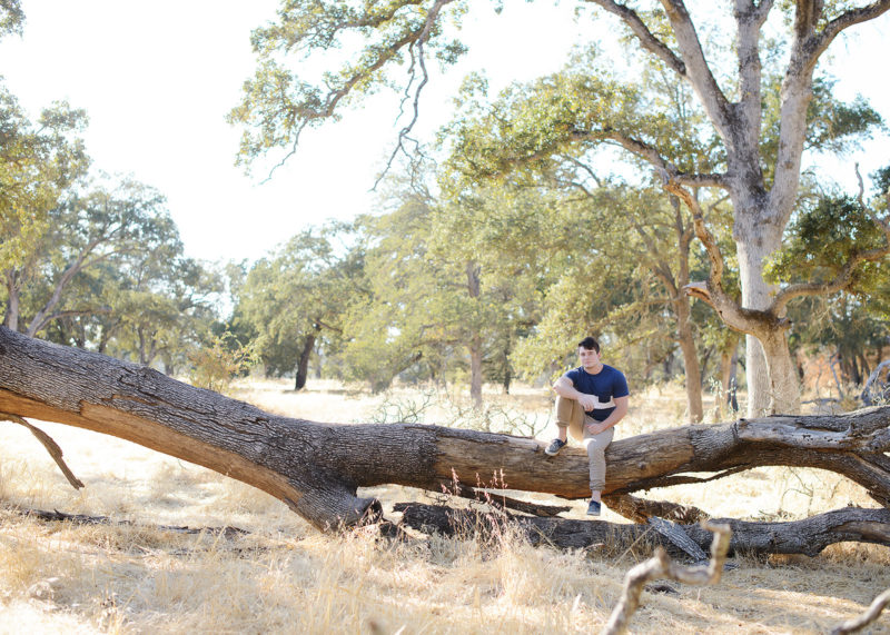 Male teenager sitting on fallen log in Folsom