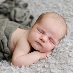 Newborn Wrapped in Gray Swaddle Sleeping