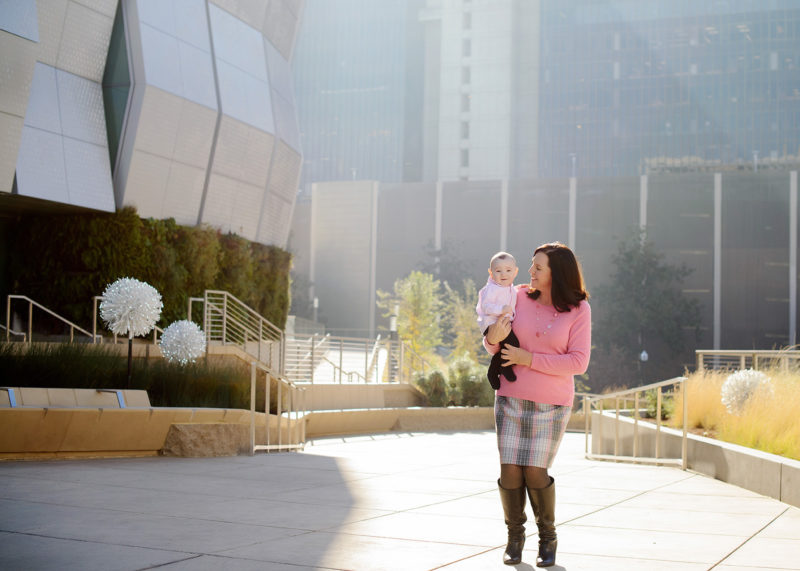 Mom Carrying Baby Boy in front of Golden 1 Center in Natural Light