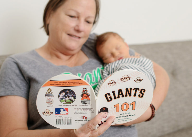 Mom reading San Francisco Giants book to newborn baby boy