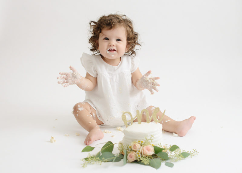 One Year Old Baby Girl Smashing Cake with Flowers