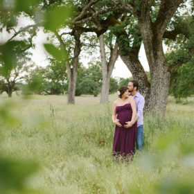 Pregnant couple hugging under a tree in Folsom
