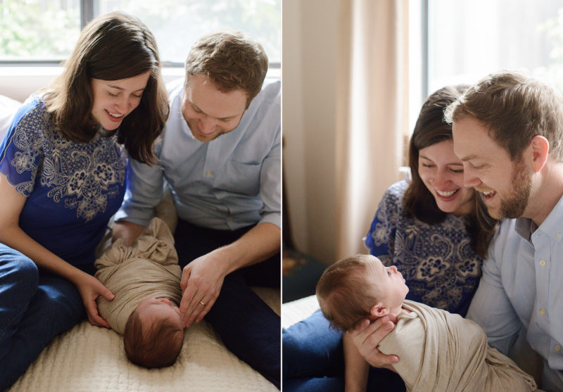 Mom and dad wearing blue looking lovingly at newborn son in tan swaddle