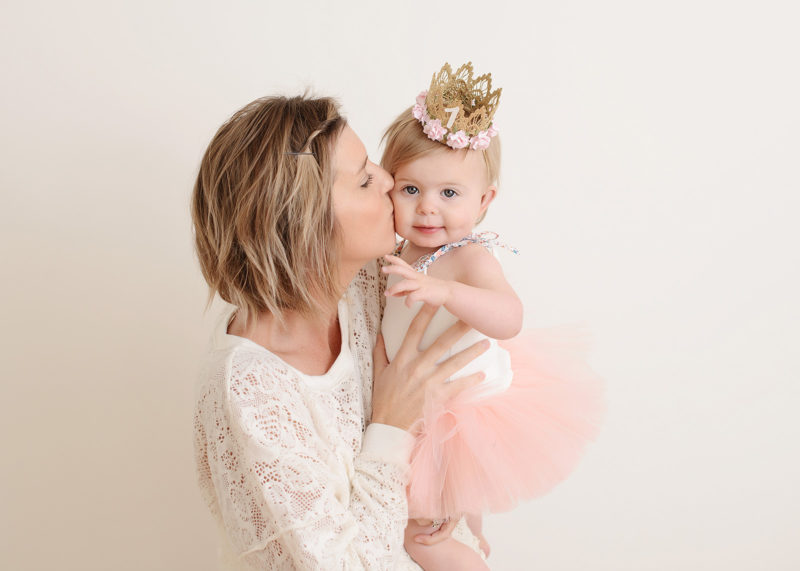 Mom kissing baby girl and celebrating one year