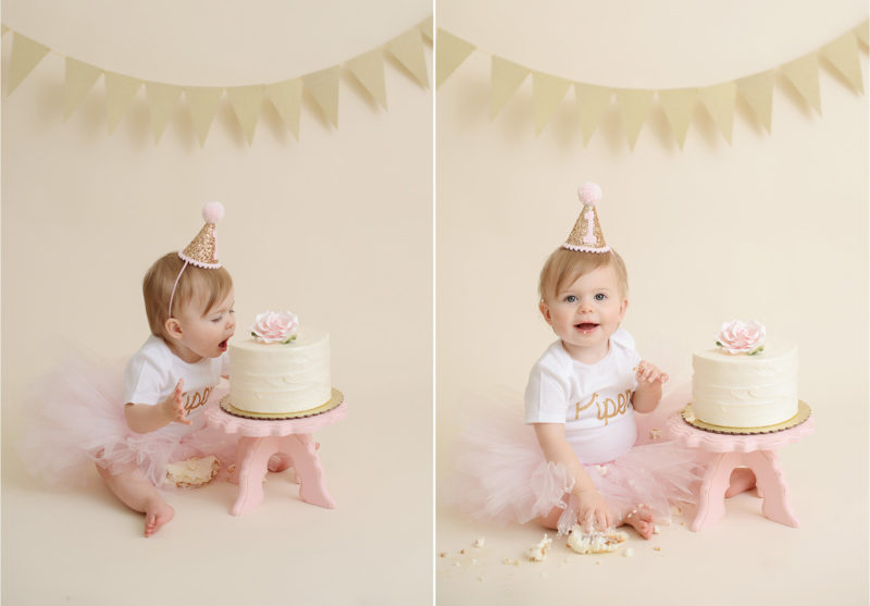 Baby girl wearing pink tutu diving face first into cake against gold bunting