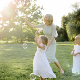 Mom and daughters blowing bubbles outdoors in Sacramento