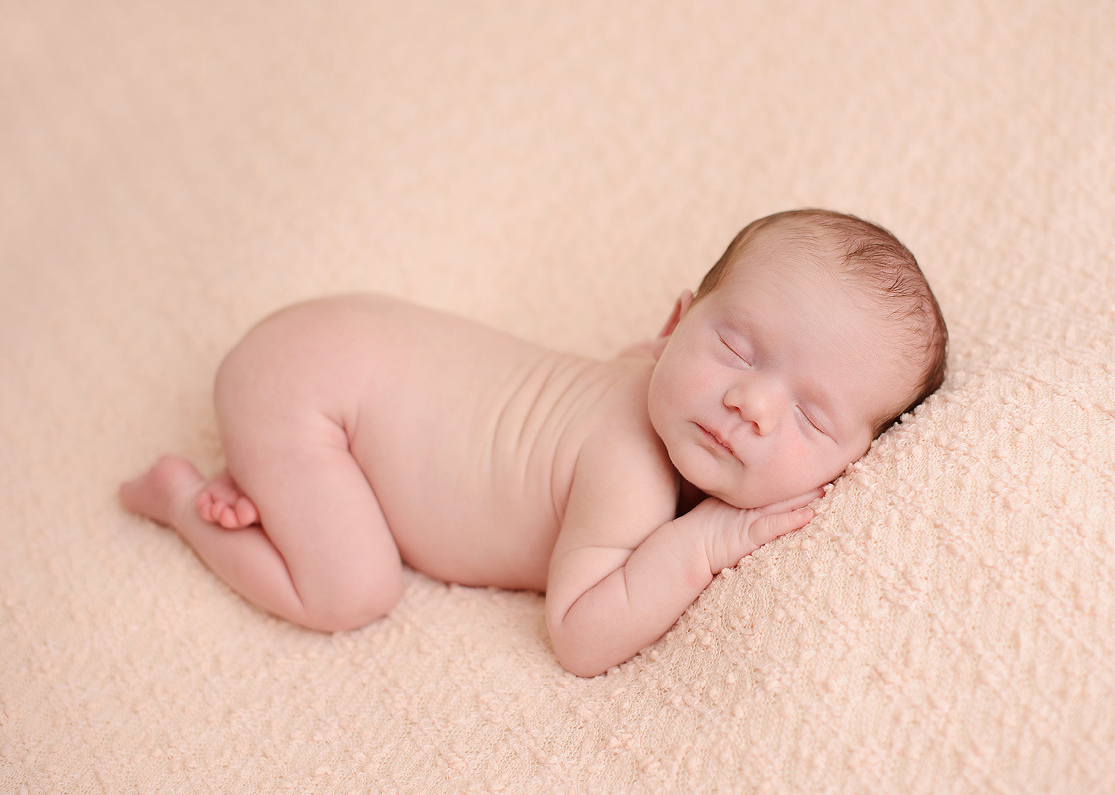 Newborn baby girl sleeping on pink blanket