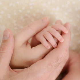 Newborn baby close up of hands with parents hands