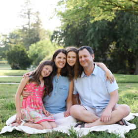 Family hugging on a picnic blanket in Sacramento park