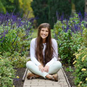 Senior girl portrait sitting down in wildflower garden in Sacramento