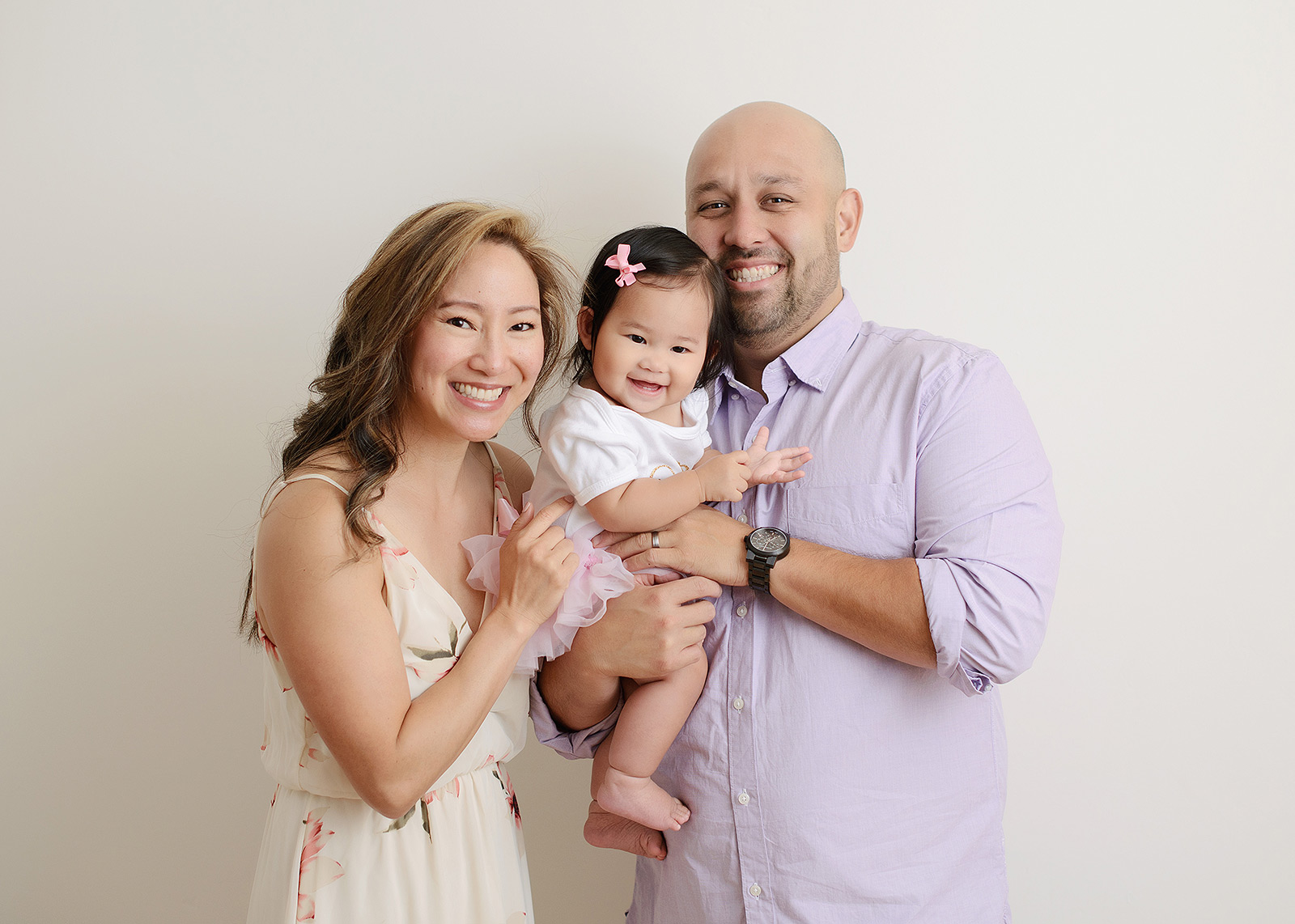 Family with one year old baby girl smiling