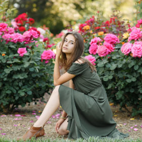 Senior girl posing by pink flowers outdoors in Sacramento State Capitol