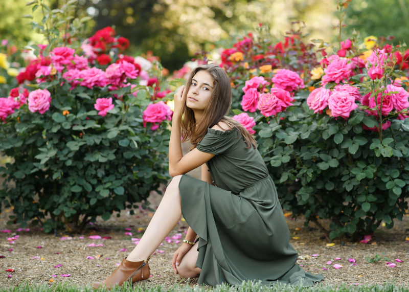 Senior girl posing by pink flowers outdoors in Sacramento State Capitol