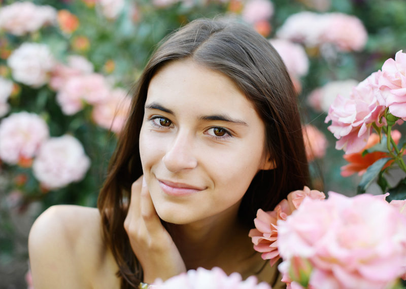 Senior portrait of teen girl in the middle of pink flowers in State Capitol