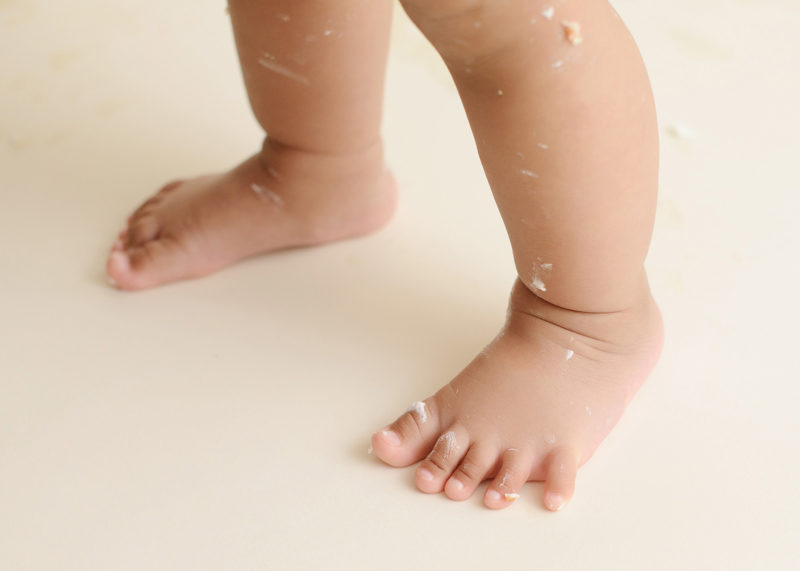 Baby girl's feet with frosting from cake smash