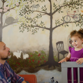 Toddler girl in nursery crib looking at dad