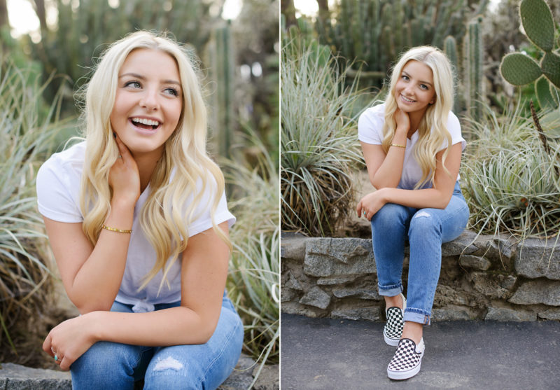 Senior portrait of blonde girl in jeans and sneakers sitting down at State Capitol outdoors