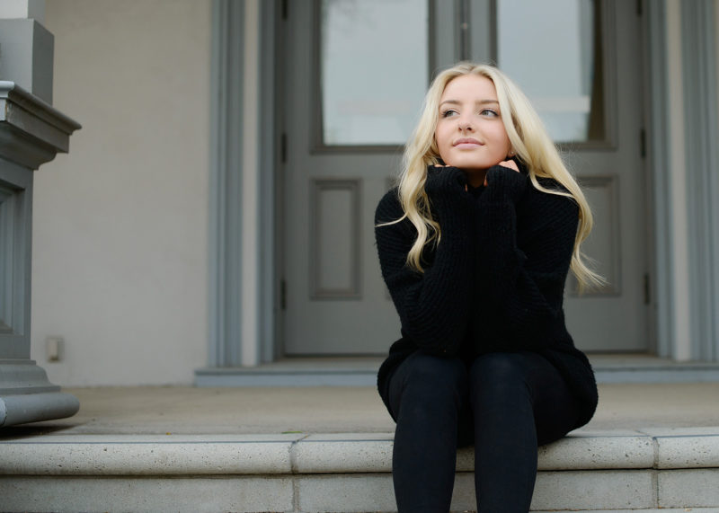 Senior portrait of teen girl wearing black turtleneck on State Capitol steps