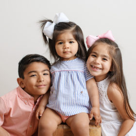Brother and sisters smiling in studio family session