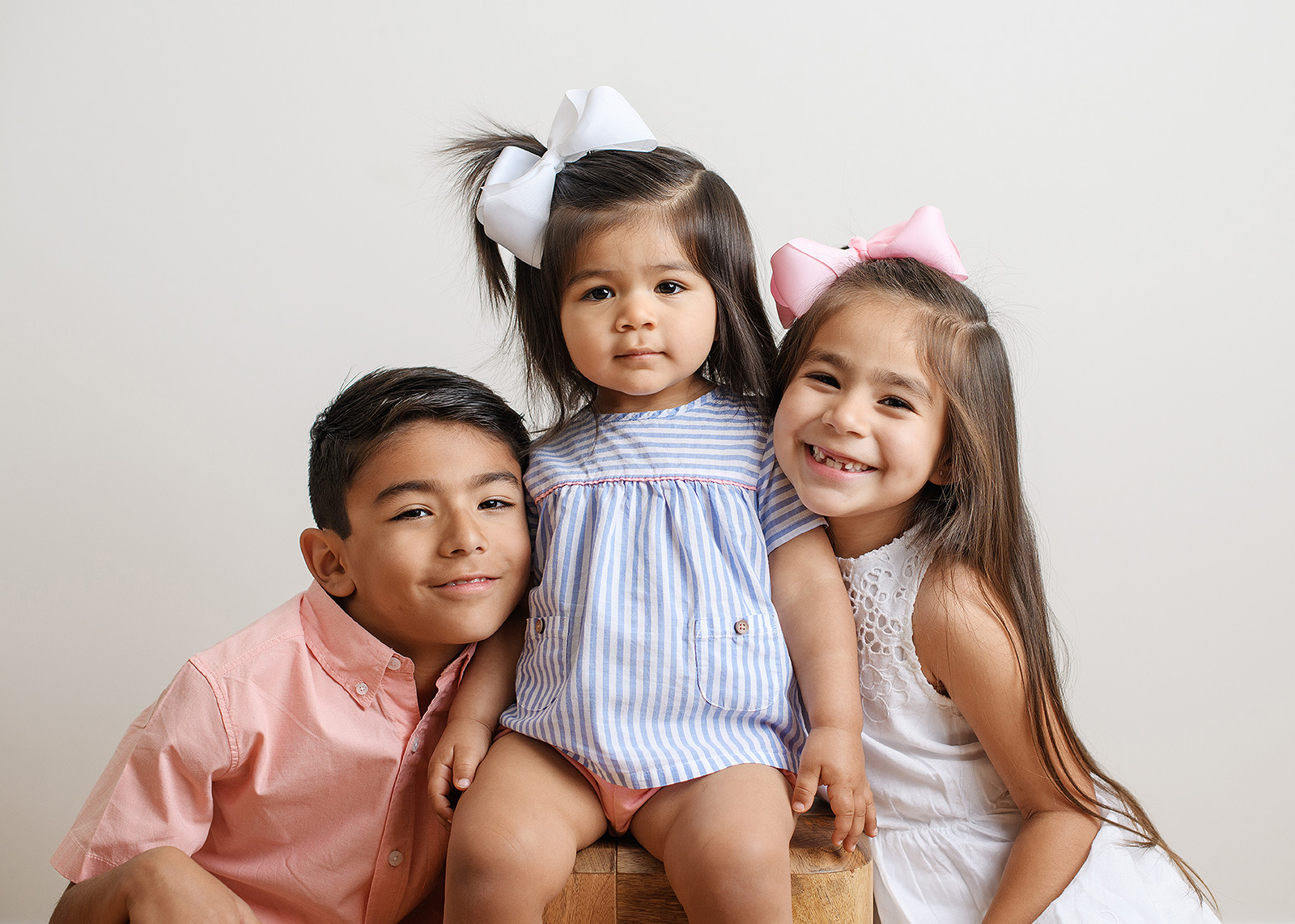 Brother and sisters smiling in studio family session