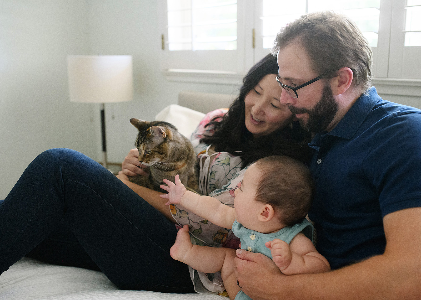 6 month baby boy petting cat on bed lifestyle session