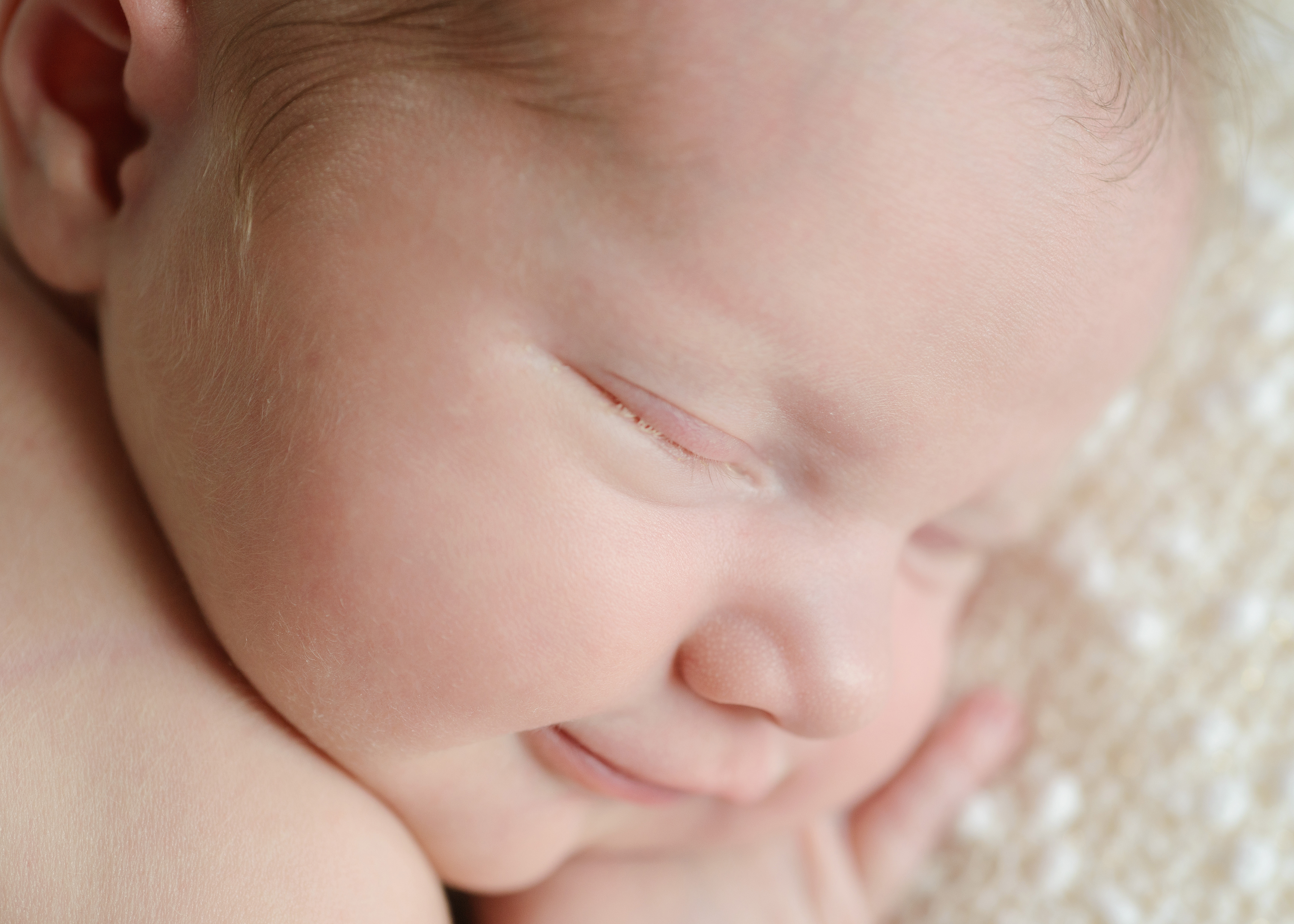 Sleepy newborn baby close up of smiling face