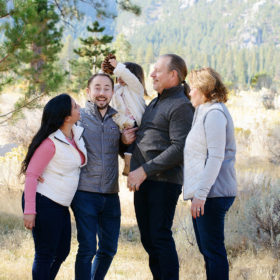 Funny family photo with daughter holding pine cone over dad’s head in outdoor Nevada