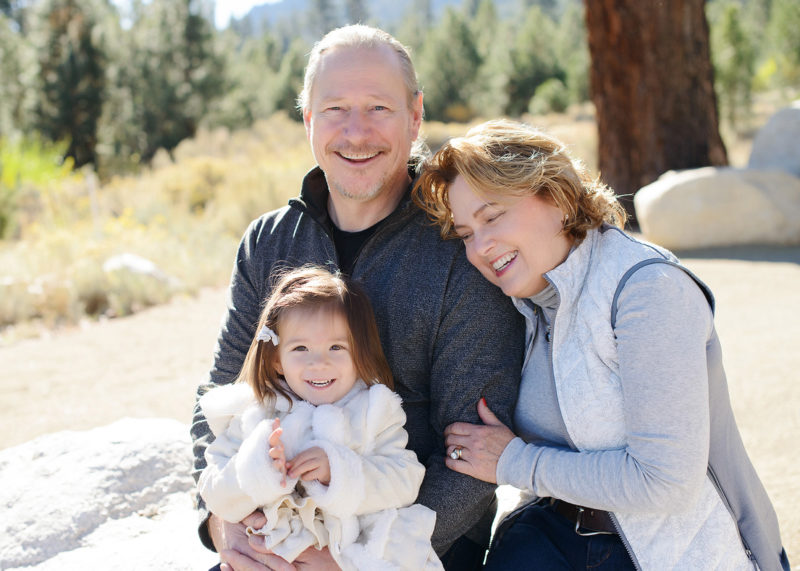 Grandparents snuggling close to granddaughter in Nevada outdoors