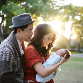 Asian couple with newborn baby girl holding and watching her lovingly in Oak Park Sacramento